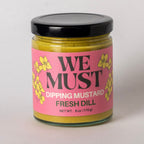 Jar of 'We Must' Dipping Mustard with pink label on a light gray background